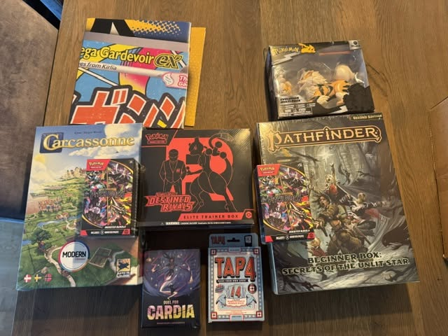 Premiene fra Cardcenter til skolemesterskapet: Pokémon-produkter og brettspill på et bord.