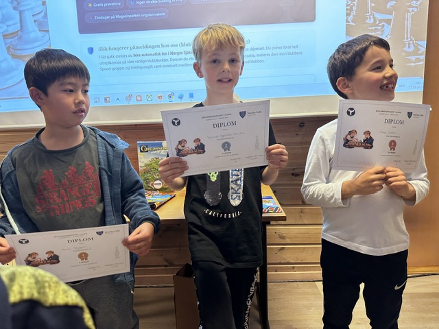 Tre barn med diplomer fra premieutdelingen