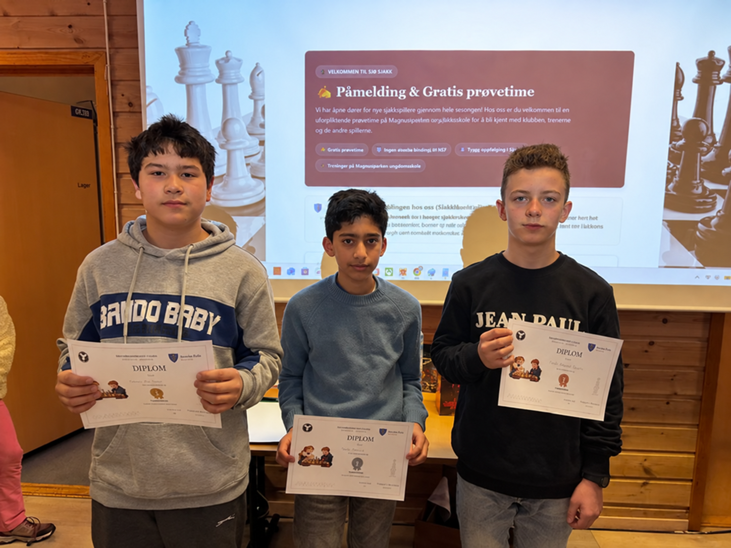Tre ungdommer med diplomer under premieutdelingen